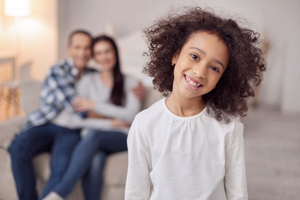 Child standing in front of parent and stepparent