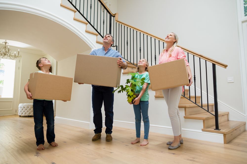 family carrying moving boxes