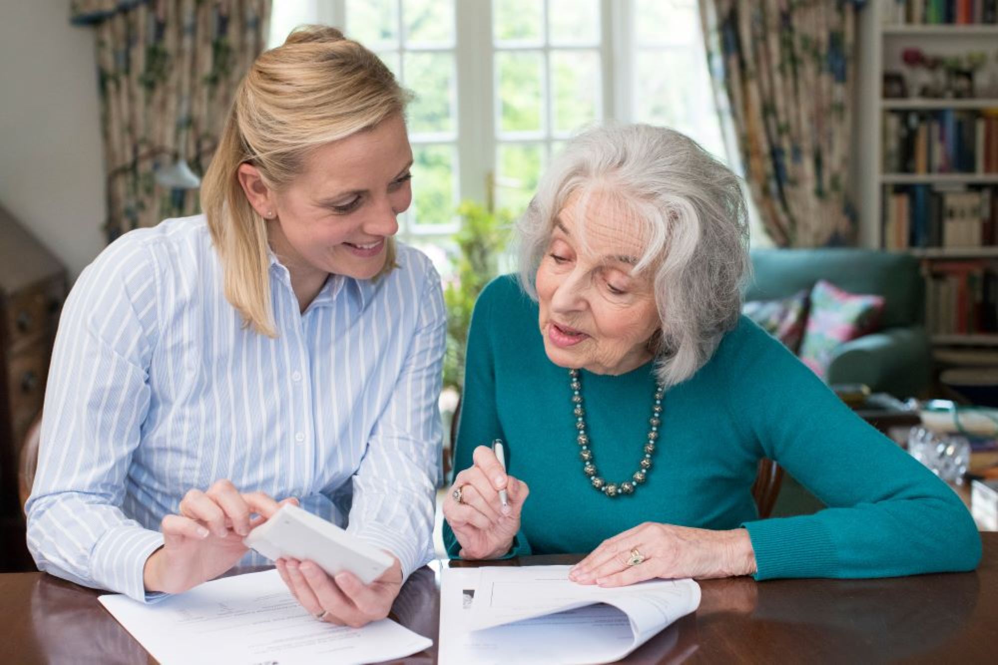older adult looking over paperwork with younger adult